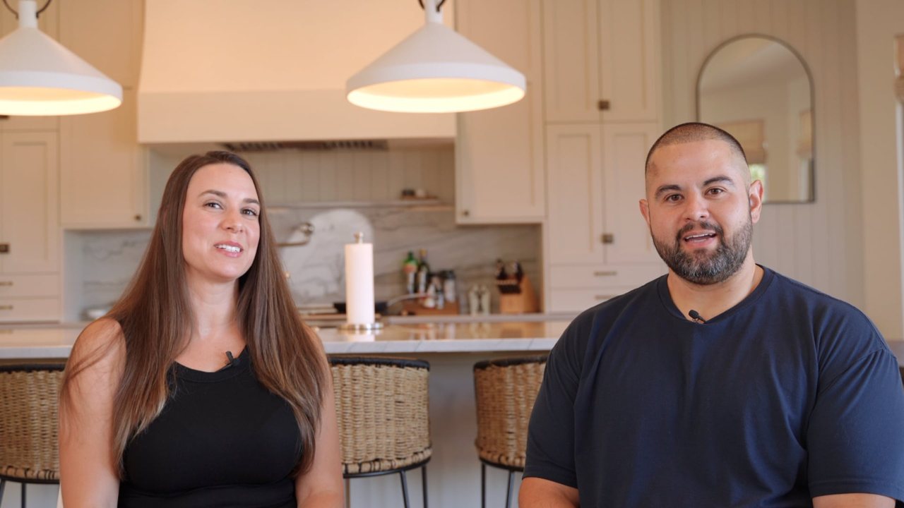Ashly Childers and her husband seated in their kitchen during their filmed testimonial