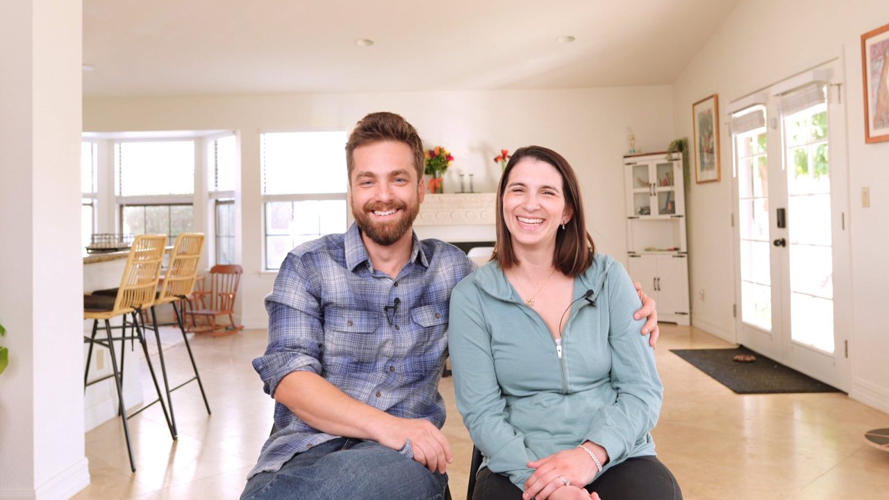Sophie Esther and Yossi seated in the front room of their first family home during their filmed testimonial